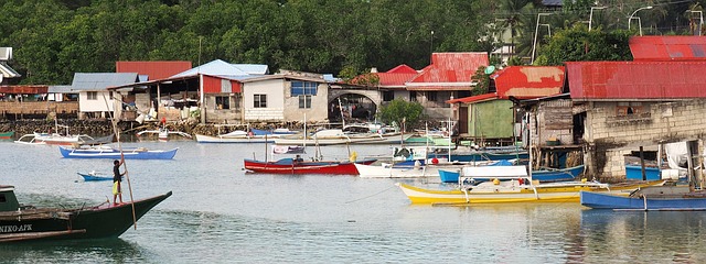 Traditional Filipino stilt houses and fishing boats in a Palawan coastal village near Balabac