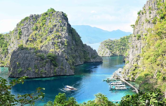 Coron Palawan lagoon with limestone mountains cliffs and boats Philippines
