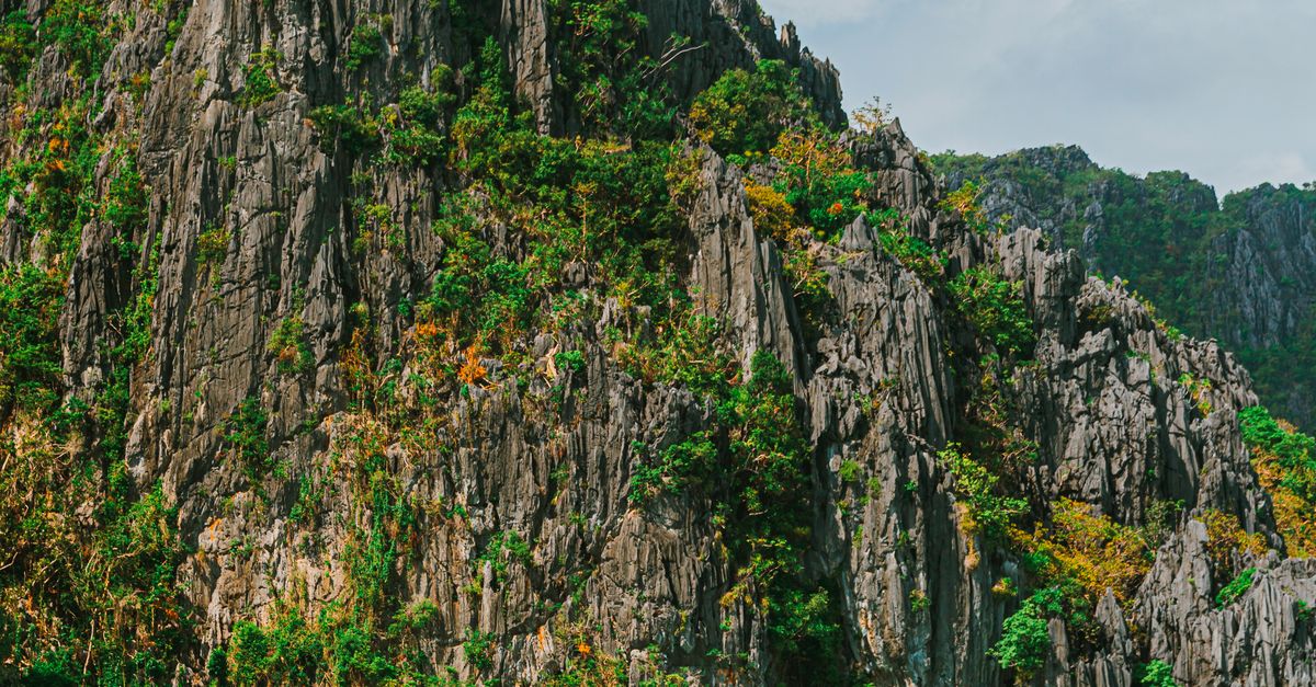 Kayaking beneath limestone cliffs at Big Lagoon El Nido Palawan Philippines