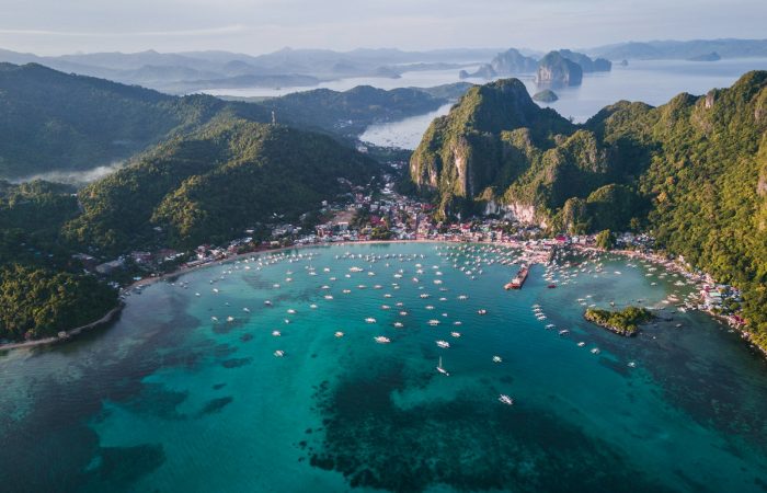 Aerial view of a Bacuit Bay island and boats on El Nido Tour B route, Palawan