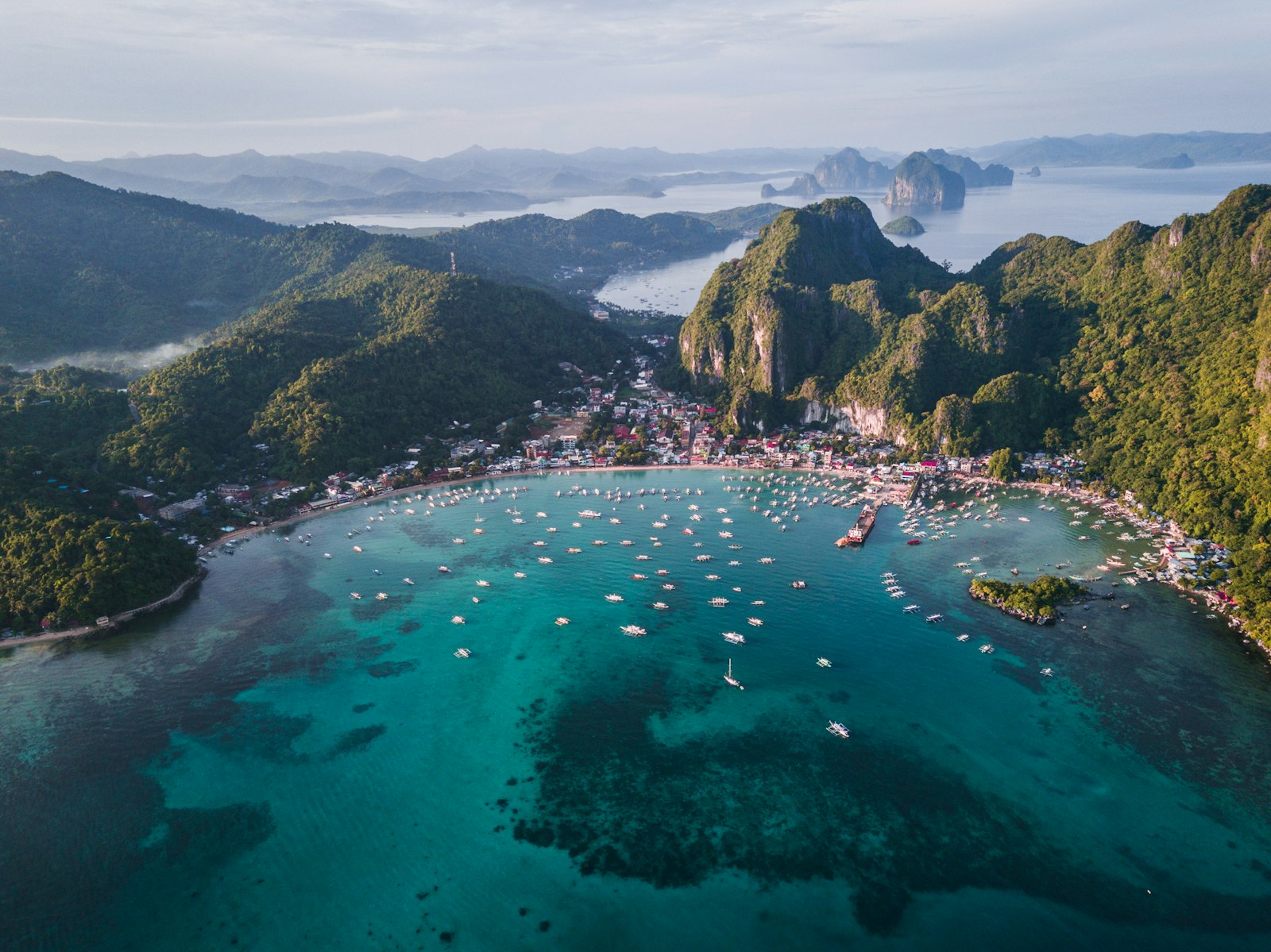 Aerial view of a Bacuit Bay island and boats on El Nido Tour B route, Palawan