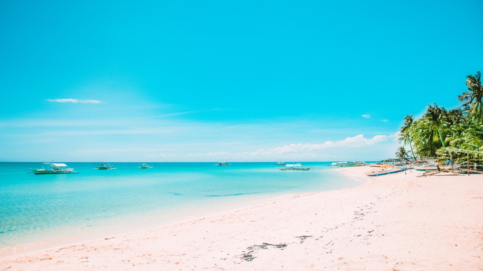 Quiet uncrowded beach with boats in Port Barton Palawan Philippines