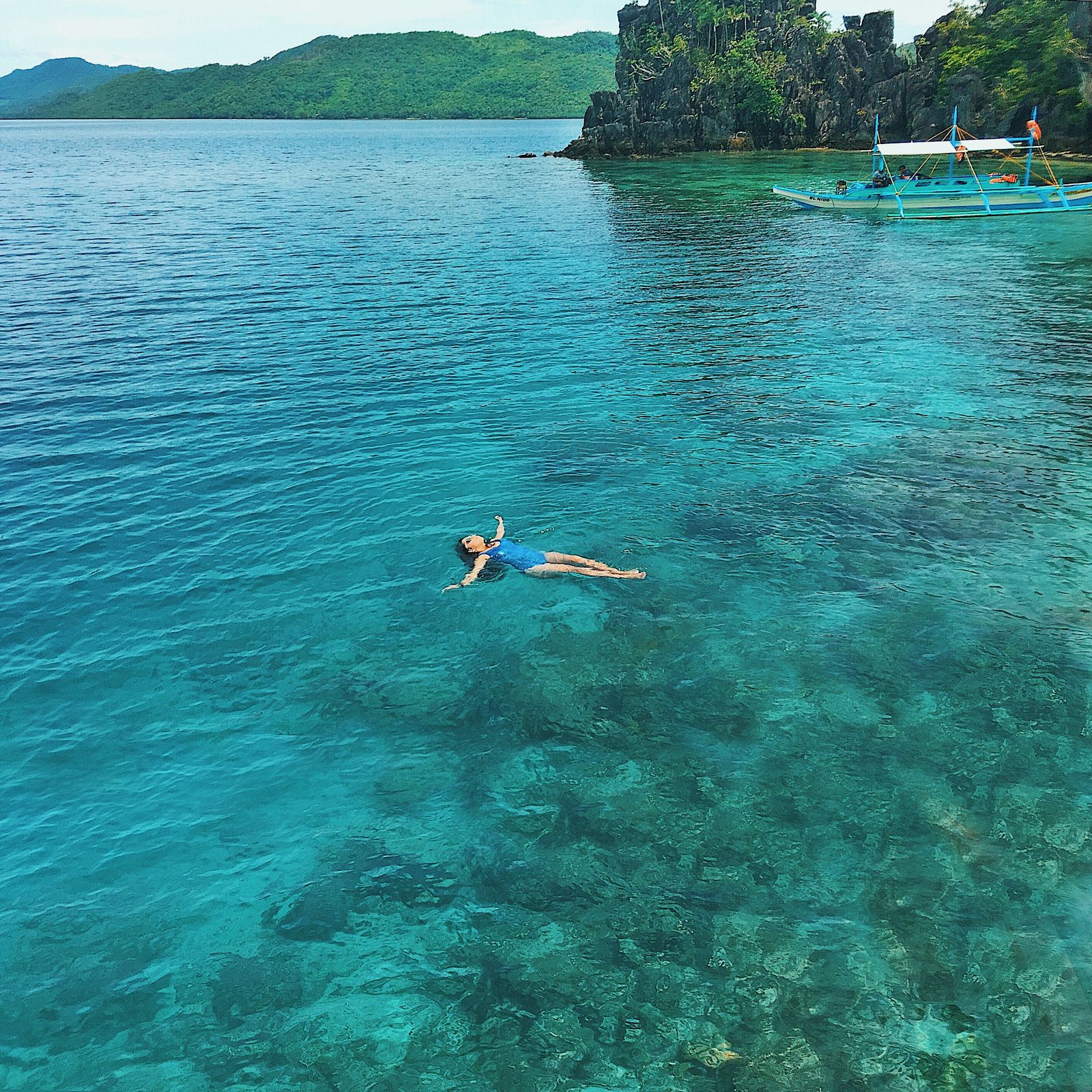 Snorkeler swimming in clear turquoise water near Port Barton Palawan