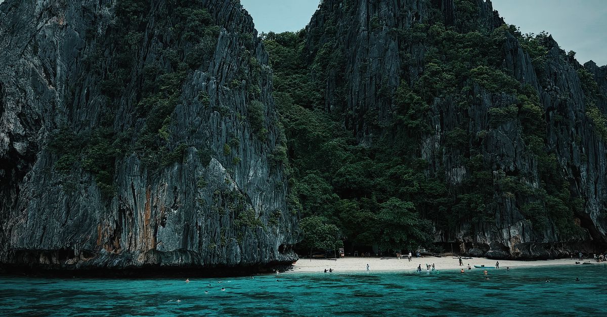 Limestone cliffs and turquoise cove near Small Lagoon El Nido Palawan Bacuit Bay