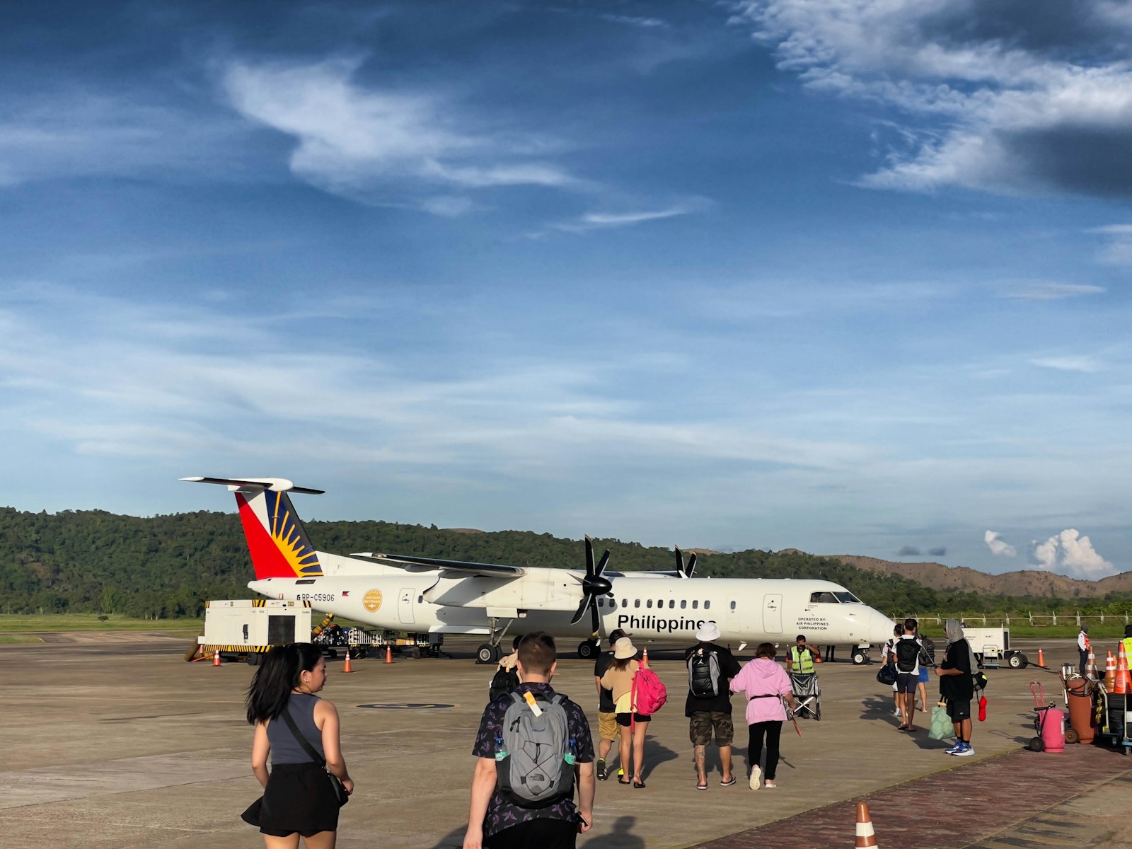 Small propeller plane boarding passengers for a flight connecting to Busuanga, Coron