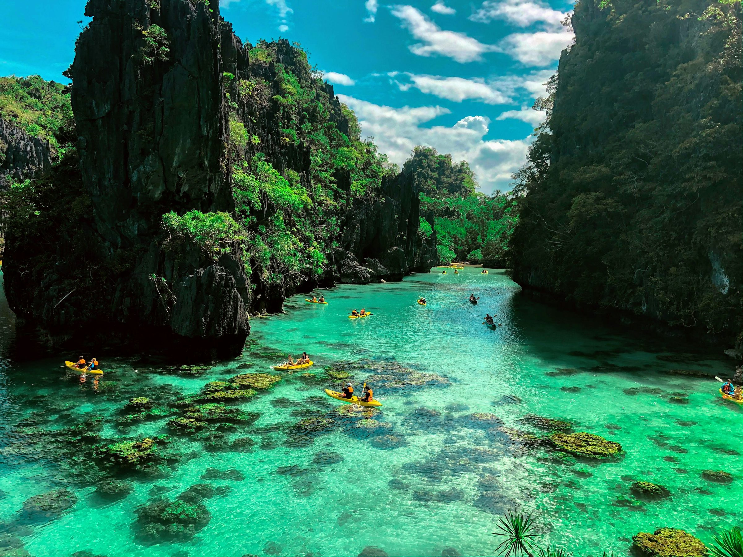 Swimmers among limestone rocks in El Nido Palawan, a common stop on the Puerto Princesa to Coron journey