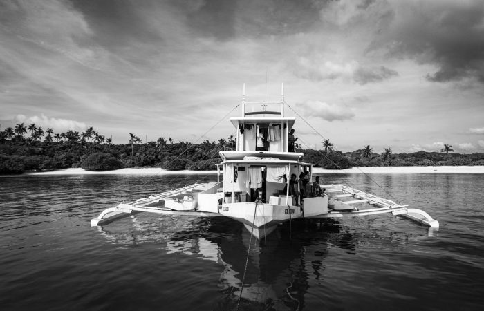 Traditional bangka boat on calm water off a Palawan white sand beach, things to do in Port Barton