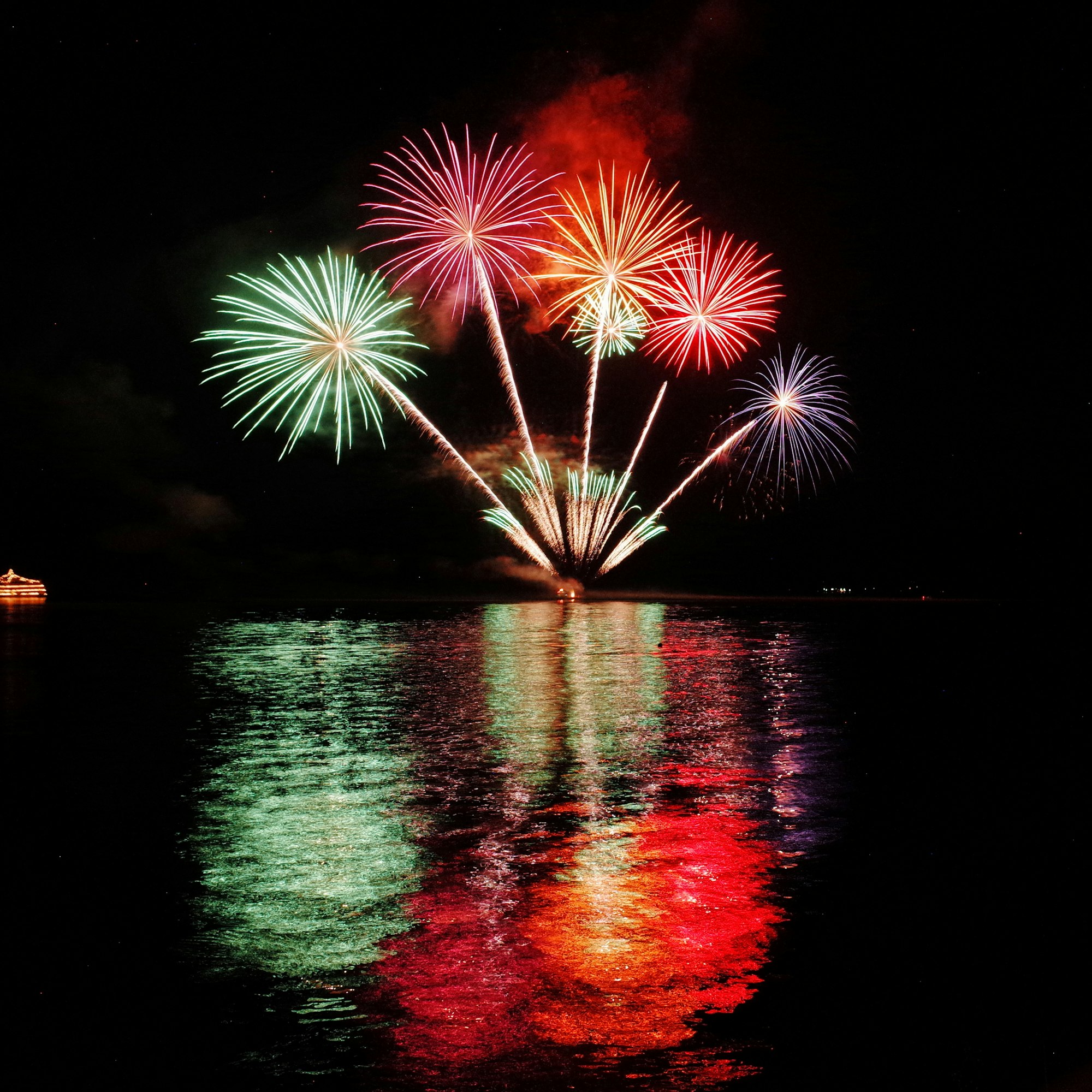 Summer fireworks reflected over Lake Toya, part of the festival season when you visit Japan