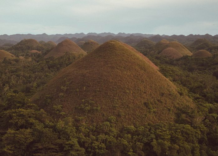 The Chocolate Hills of Bohol under a cloudy sky