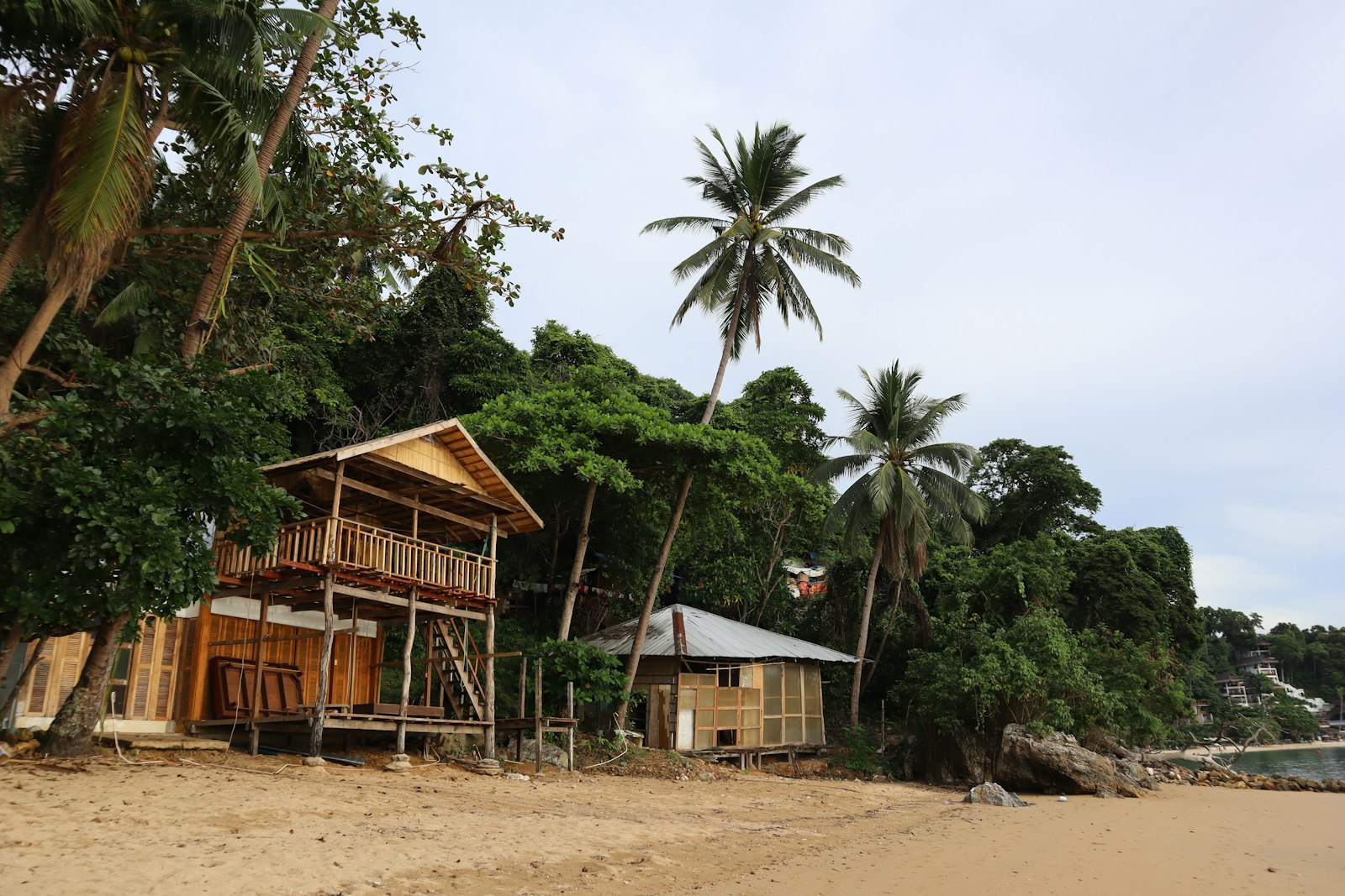 Beachfront wooden bungalows and palm trees in El Nido, a typical mid-range El Nido budget per day stay