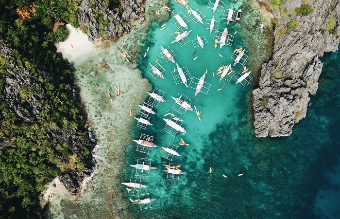 Aerial view of boats and karst cliffs in El Nido, the busiest base in this Palawan accommodation guide