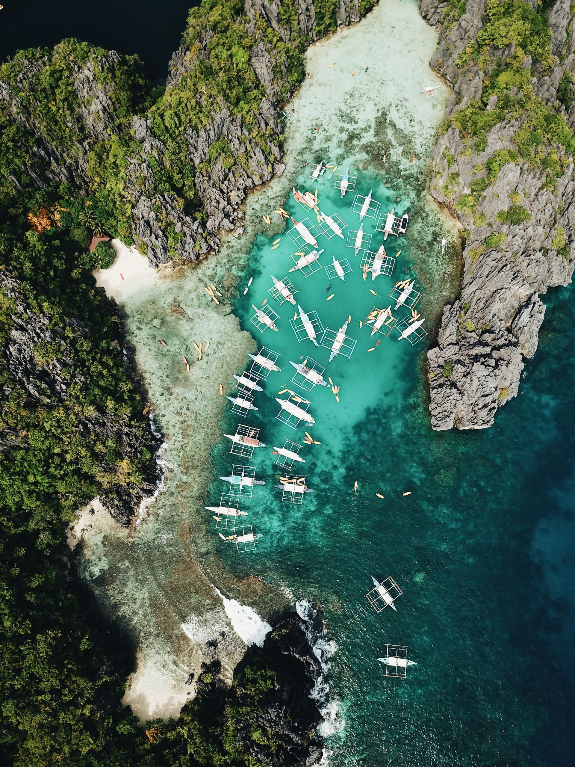 Aerial view of boats and karst cliffs in El Nido, the busiest base in this Palawan accommodation guide
