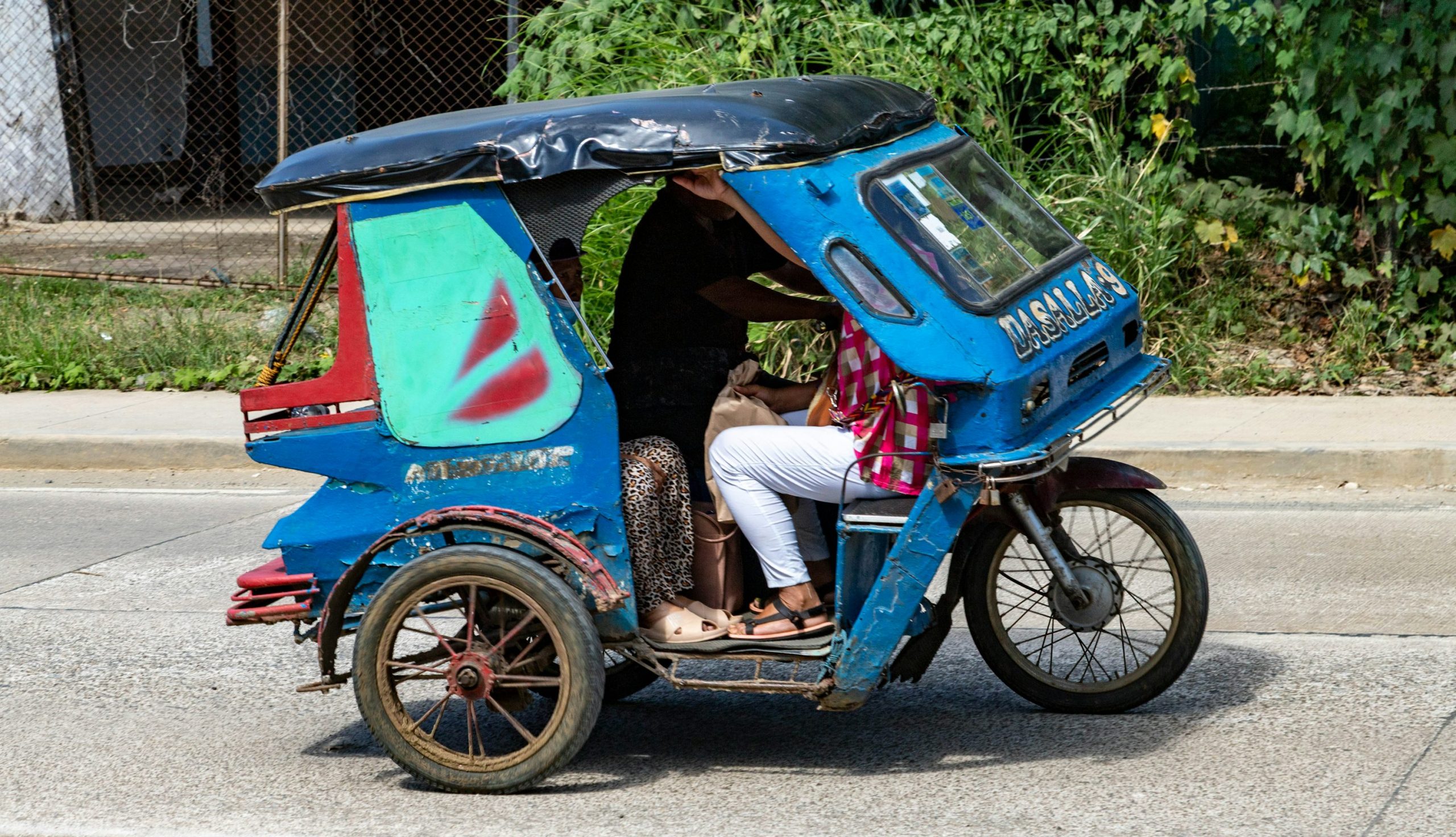 port-barton-budget-travel-featured.jpg Tricycle on a sunny road in Puerto Princesa, the starting point for Port Barton budget travel by shared van