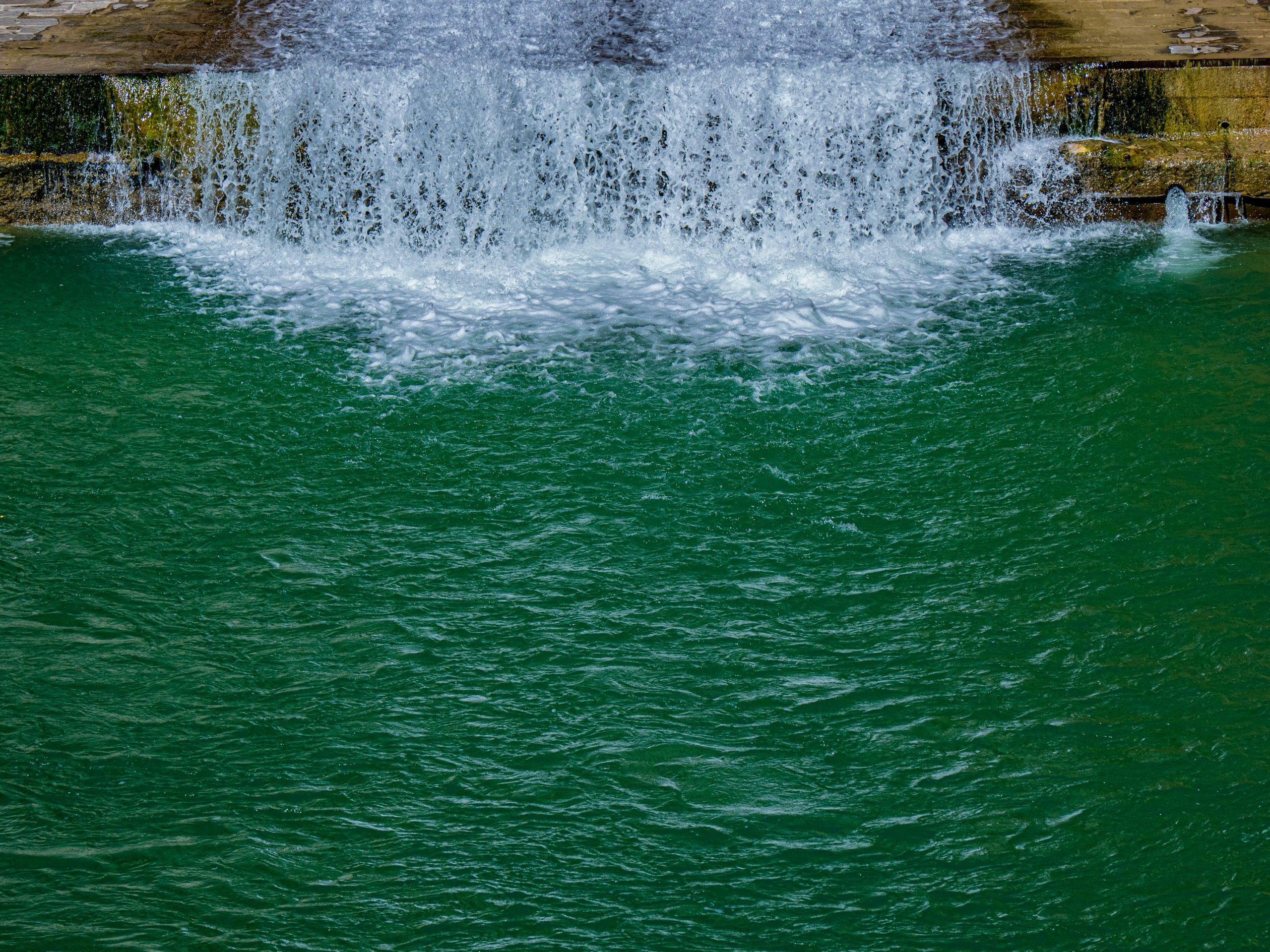 Jungle waterfall falling into a clear green pool, the kind of free day out that makes Port Barton budget travel work